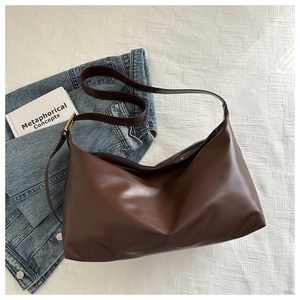 Detail view of large brown faux leather tote bag with adjustable strap and zipper closure