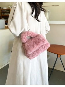 Gros plan détaillé du mini sac en peluche rose avec une bandoulière en chaîne fine
