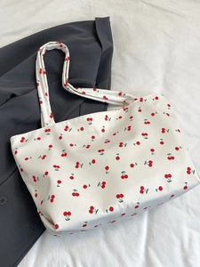 Détail du sac cabas en toile blanche avec imprimés cerises et longues anses