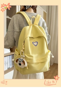 Detail of yellow canvas backpack with purple heart print and cute cartoon dog pendant