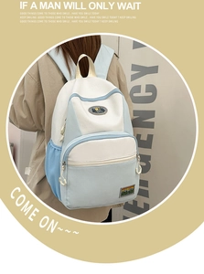 Detail of blue and white nylon backpack with mountain embroidery and durable handle