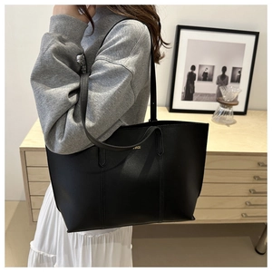 Detailed view of black large capacity tote bag with elegant gold BAGS lettering decoration