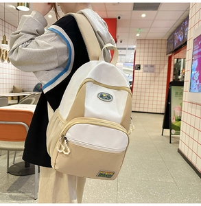 Detail of a nylon backpack featuring side mesh pockets and mountain logo patch on the front