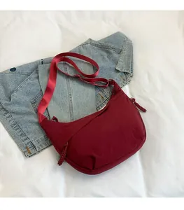 Détail du sac bandoulière en nylon bordeaux avec tissu texturé et sangle réglable