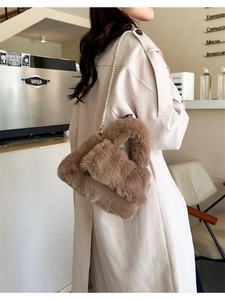 Détail d'un sac à main en peluche marron avec chaîne en perles et texture douce