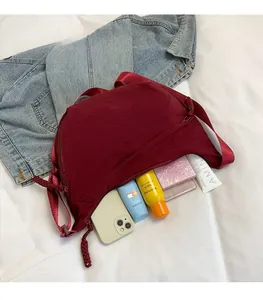 Détail de l'intérieur du sac besace bordeaux avec un grand espace de rangement quotidien