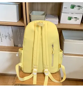 Detail view of light yellow backpack back featuring padded straps and hidden zipper pocket