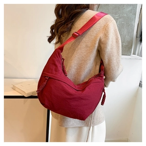Vue détaillée du sac bandoulière croissant bordeaux en nylon avec sangle réglable