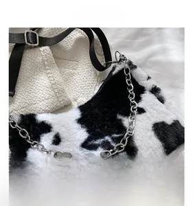 Detail view of plush faux fur texture and silver chain on cow print tote bag