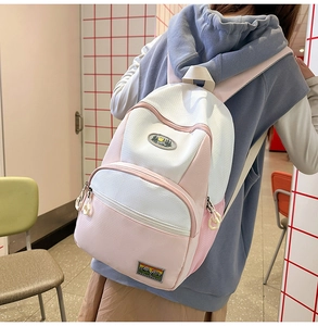 Detail view of nylon backpack featuring scenic patches and geometric zipper pendants