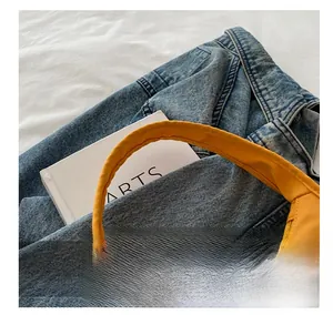 Close-up of comfortable yellow nylon handle with precise stitching on a tote bag