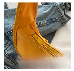 Detailed close-up of smooth resin zipper on a vibrant yellow casual shoulder handbag