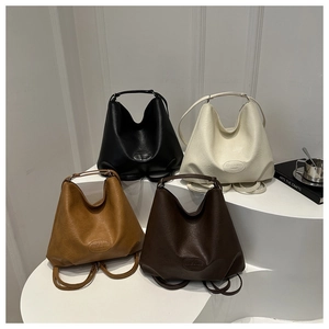 Fashionable minimalist tote bags in four colors displayed on a modern geometric white pedestal