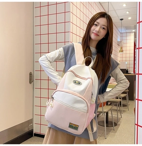 Macro shot of pink and beige nylon backpack with double zippers and retro woven labels