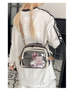 Modèle portant un sac Itabag beige et noir avec bandoulière réglable et fenêtre transparente