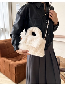 Détail du sac bandoulière en peluche blanche avec chaîne en perles et texture douce