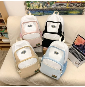 Detail showing various colors of nylon backpacks with stylish patches and multiple pockets
