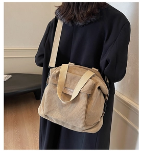 Detailed close-up of beige corduroy tote bag featuring vertical texture and fashion label