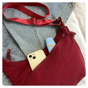 Détail du sac bandoulière croissant bordeaux en nylon avec texture et fermetures