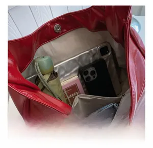 Macro view of bright red tote bag interior showing large capacity and zipper pocket