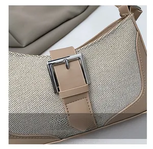 Detail of woven fabric shoulder bag with leather trim and silver metal buckle