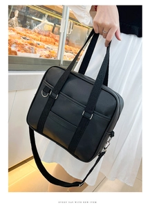 Detail of black Japanese JK uniform bag with PU leather texture and woven handles