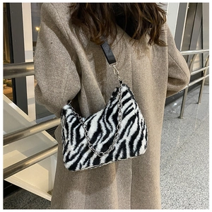 Detailed close-up of fluffy zebra print tote bag with silver chain strap and zipper