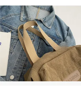 Detailed texture of brown corduroy tote bag with fashion leather patch and durable straps
