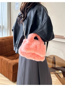 Détail d'un sac à main en peluche rose avec chaîne en perles et texture douce en fausse fourrure