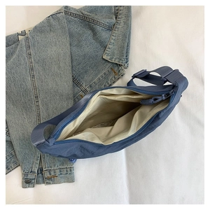 Détail du sac bandoulière en nylon bleu avec grand compartiment principal et poche interne