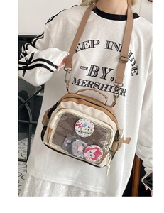 Détail de la fenêtre en PVC sur le sac ita en toile beige avec bordure marron et badges