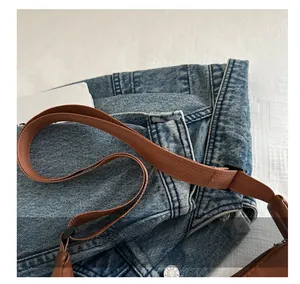 Detail of adjustable woven shoulder strap in brown with durable leather reinforcement