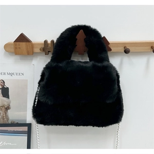 Vue détaillée d'un sac à main en fausse fourrure noire avec chaîne en perles blanches