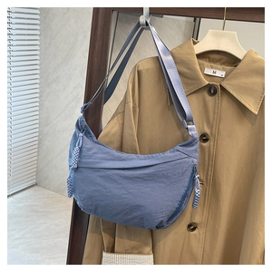 Détail du sac bandoulière croissant bleu avec texture nylon et tirette tressée