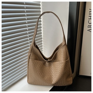 Close-up of light brown hobo bag with crocodile texture and metal magnetic closure