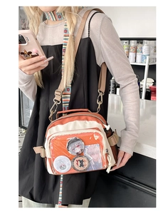 Gros plan du sac en toile orange avec fenêtre transparente et badges de personnages