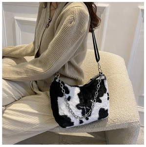 Detail showing the cow print plush faux fur texture with silver chain and leather straps
