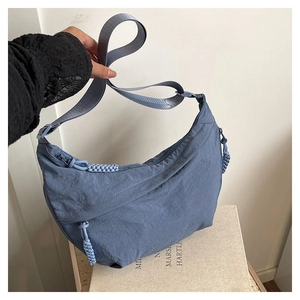 Détail du sac croissant bleu brume avec bandoulière large et tirette de zip tissée