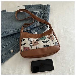 Detail of floral tapestry and brown PU leather on a stylish large capacity tote bag