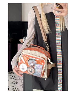 Détail du sac ita orange et blanc avec fenêtre en PVC transparent et bandoulière réglable