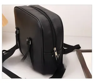 Close-up of smooth metal zipper and black PU leather texture on a square shoulder bag
