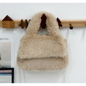 Détail d'un sac à bandoulière en fausse fourrure beige avec une chaîne de perles chic