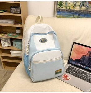 Detailed view of the blue and white nylon backpack with decorative landscape embroidery