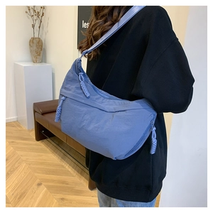 Détail du sac bandoulière en nylon bleu marine avec texture froissée et tirette tissée