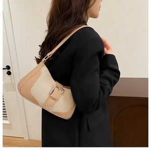 Detail showing the mixed beige canvas and leather strap of the stylish underarm bag
