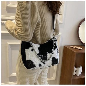 Detail of cow print faux fur tote bag showing plush texture and metal chain strap