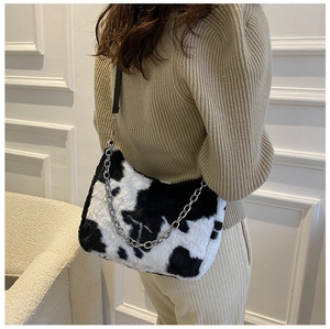 Detail of plush tote bag with cow print faux fur and silver metal chain strap