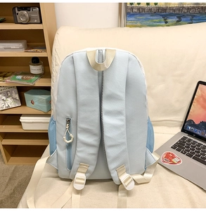 Detail view of the breathable mesh back and padded straps on the light blue nylon backpack