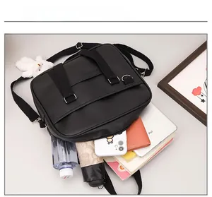 Detail view of black faux leather satchel showing capacity for iPad, umbrella and water bottle
