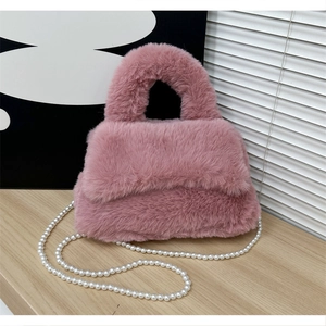 Détail d'un sac à main en peluche rose avec texture douce et bandoulière en perles blanches